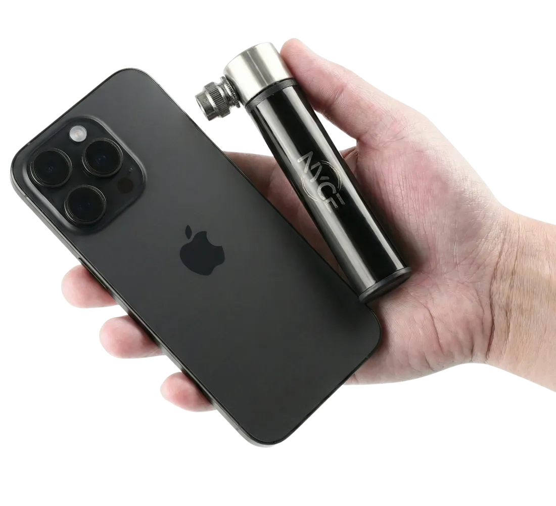 Mini pompe Ny’ce tenue en main à côté d’un iPhone pour montrer sa taille compacte et son format ultra-portable